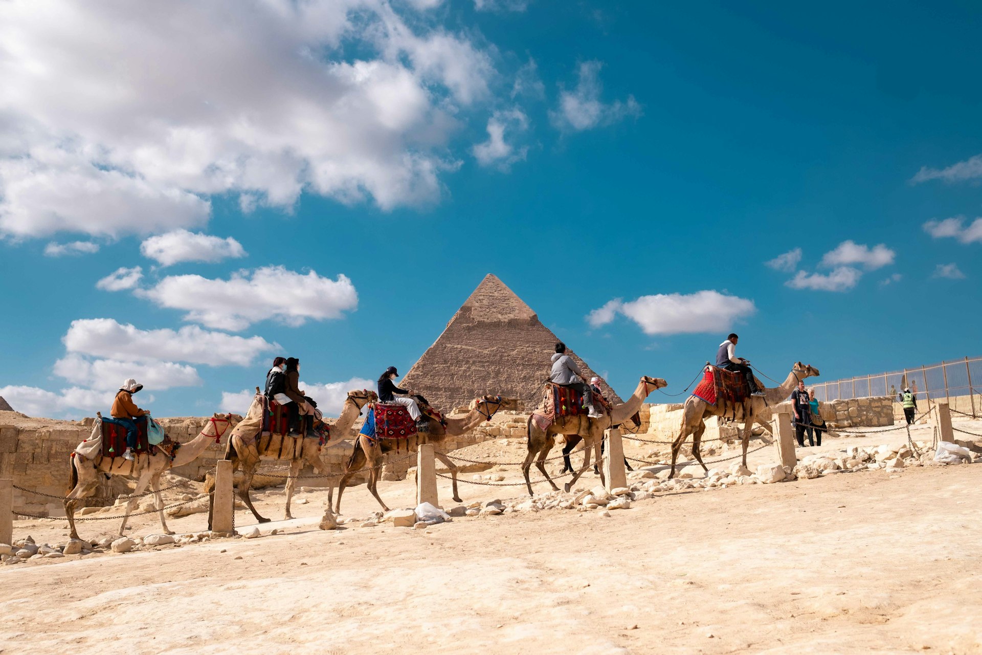 A group of people riding on the backs of camels